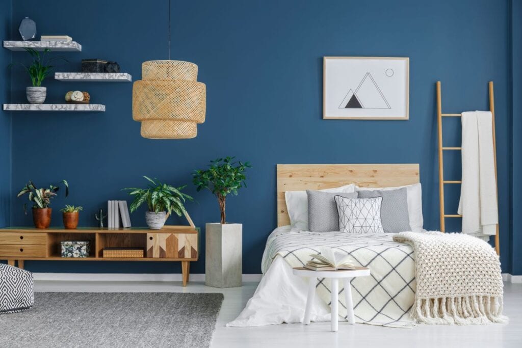 Bedroom with dark blue wall and floating shelves