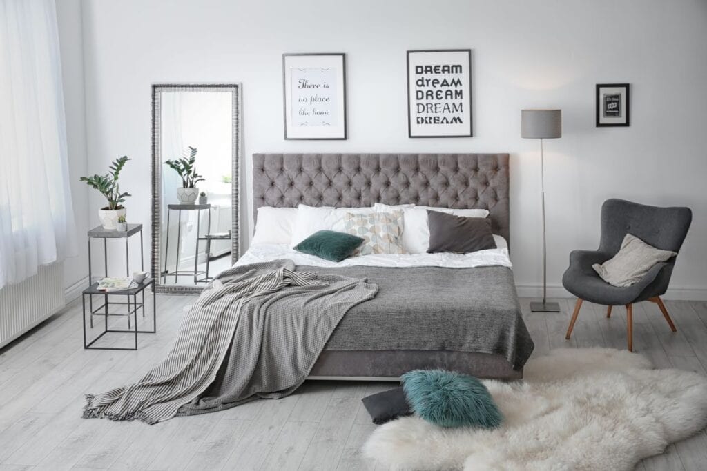 Modern bedroom with gray bed and tall standing mirror
